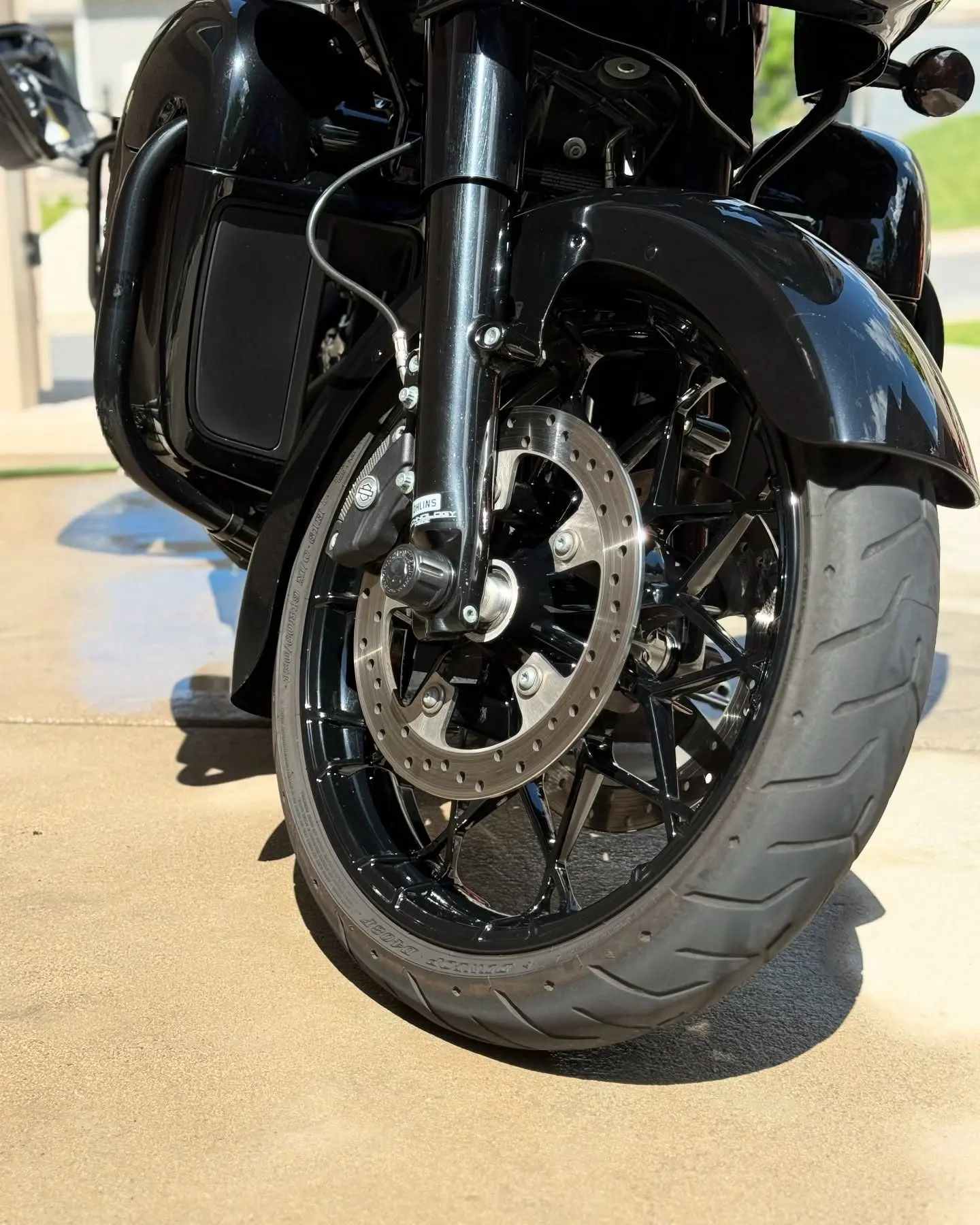 The front wheel and fender of a black Harley bagger