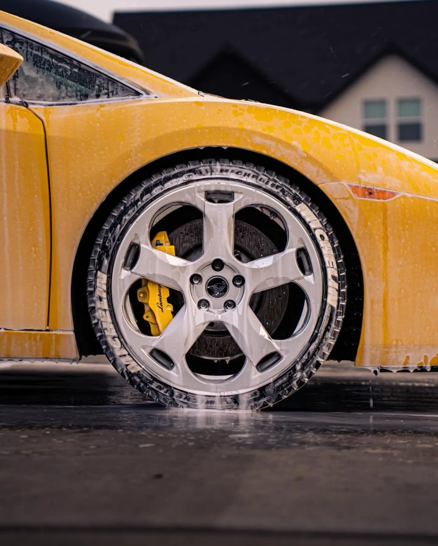 A yellow Lamborghini Gallardo wheel covered in wash foam