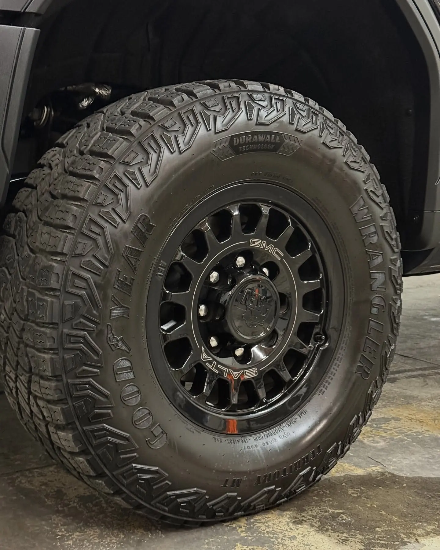 A black GMC HD wheel and all-terrain tire, dressed and clean