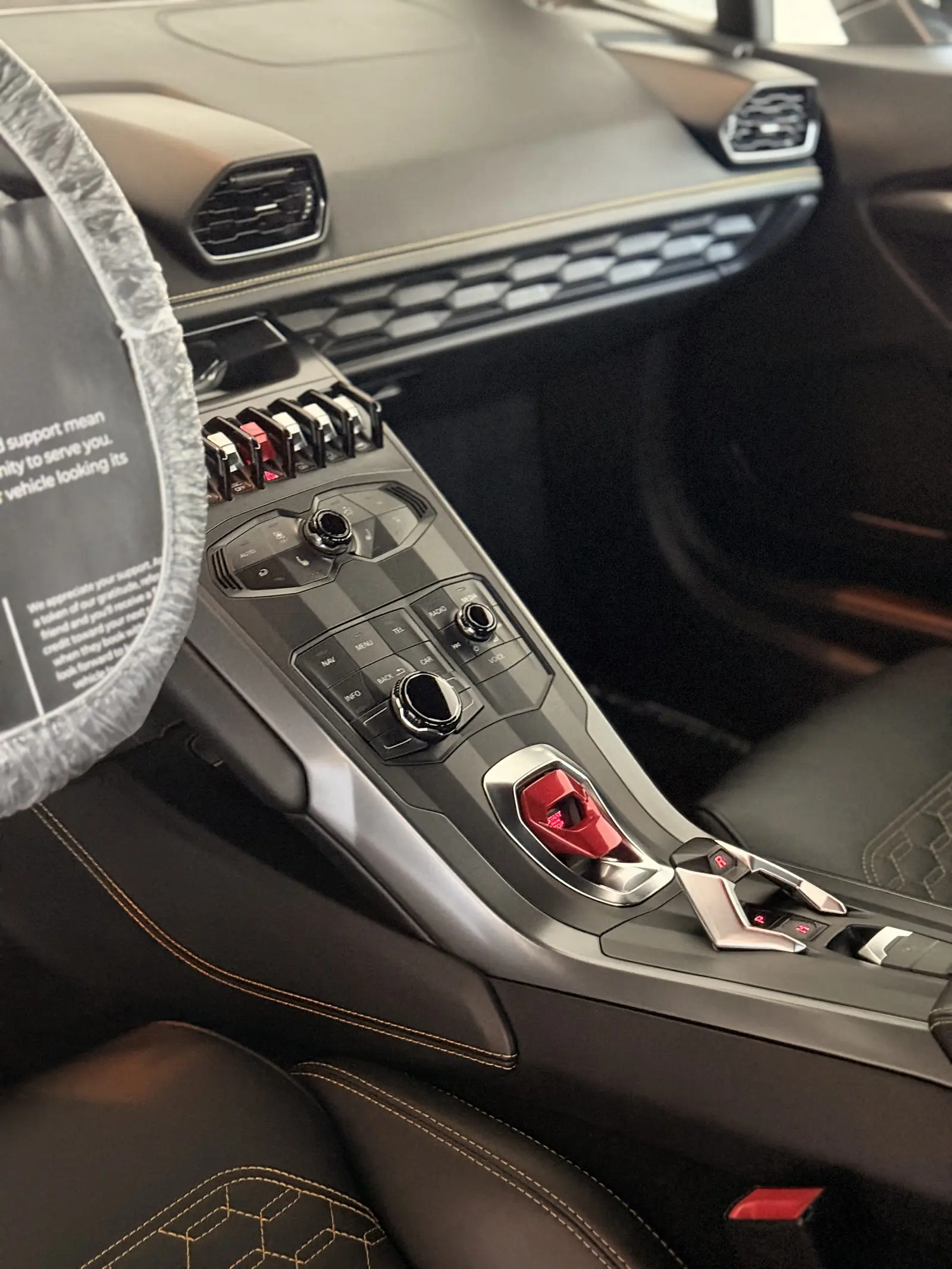 The carbon console of a Lamborghini Huracan, wheel wrapped for protection