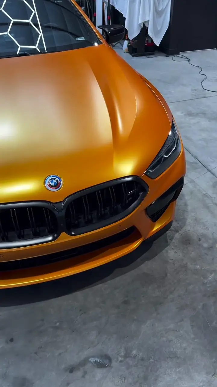The nose of an orange BMW M8 after a detail