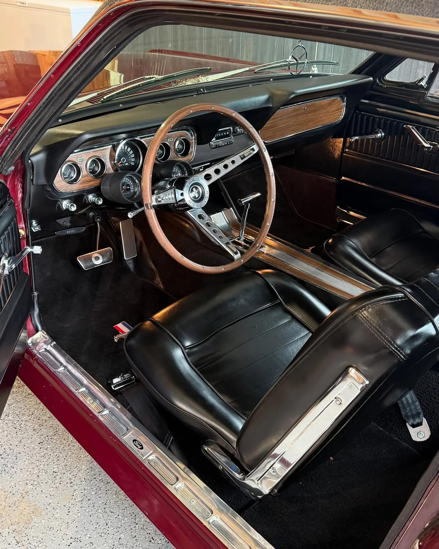 The wood-rimmed wheel and black cabin of the 1966 Mustang