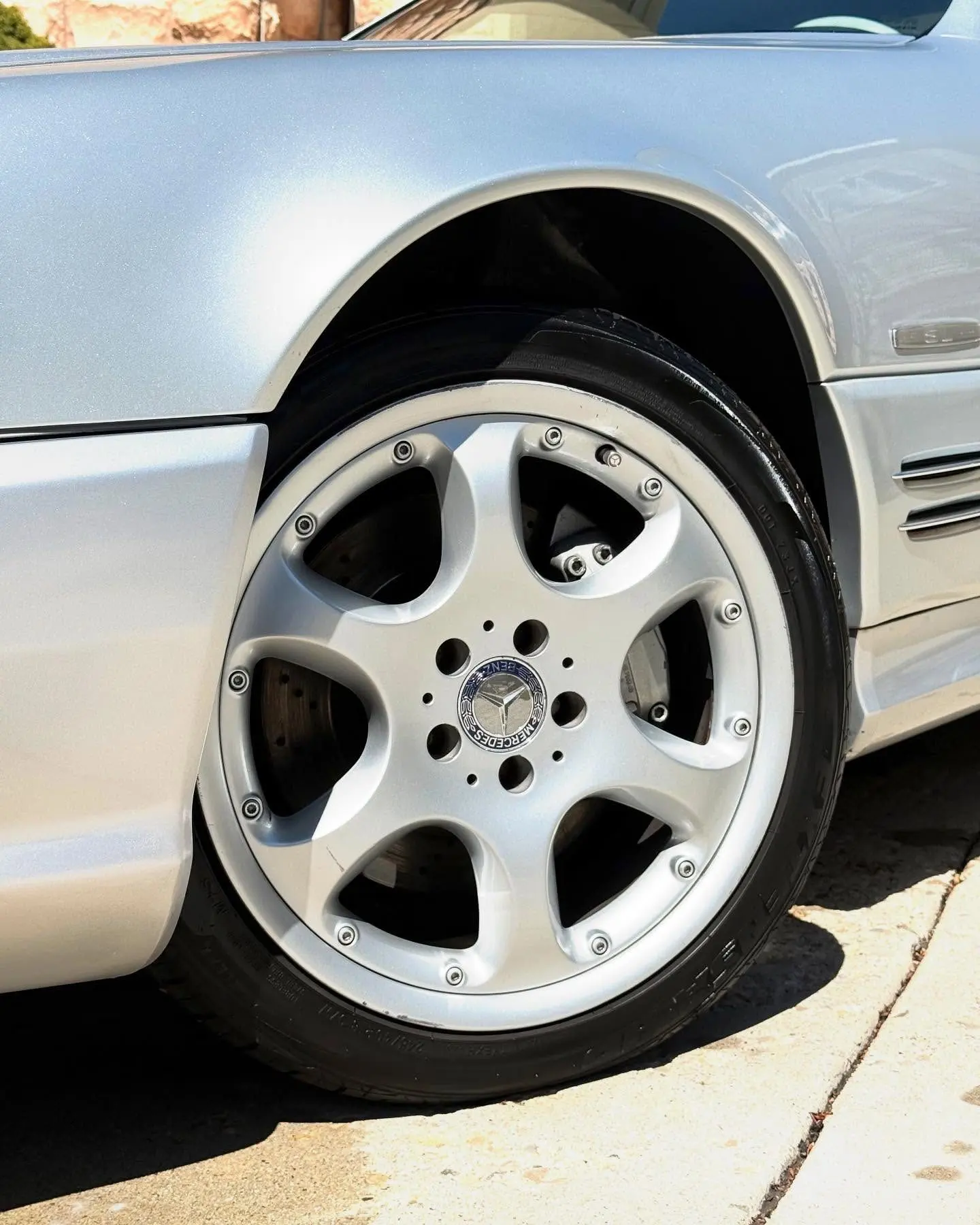 The front wheel of a silver Mercedes SL500 after a detail