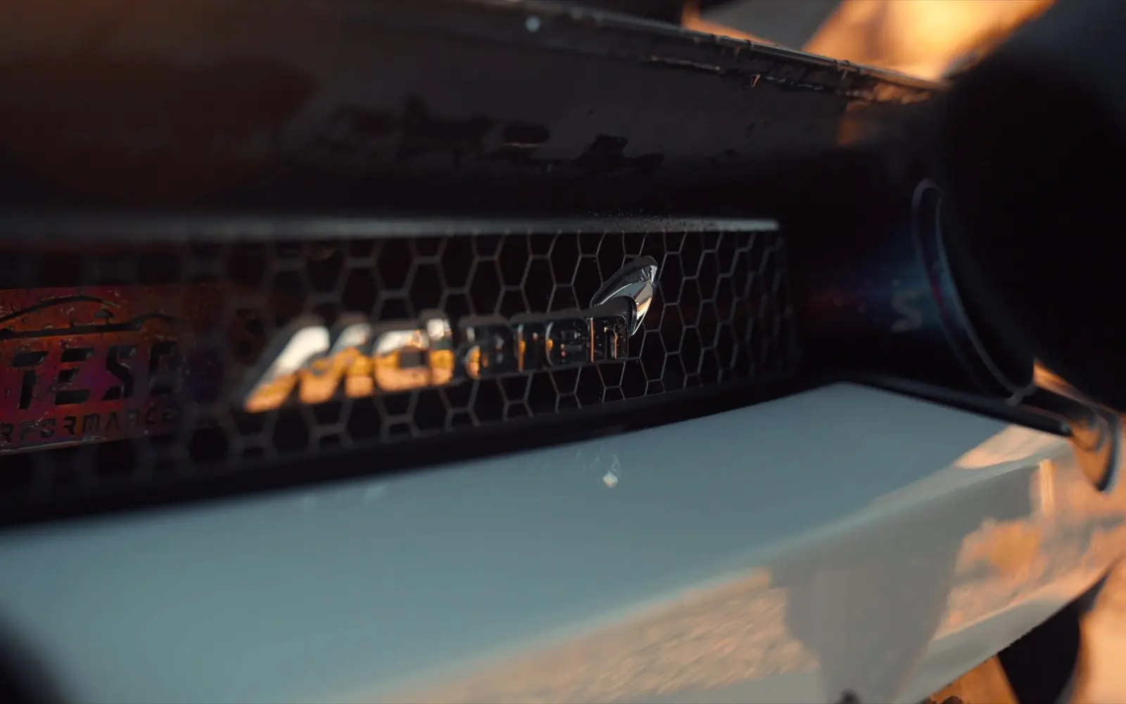 The mesh grille and badge on the nose of a white McLaren 720S