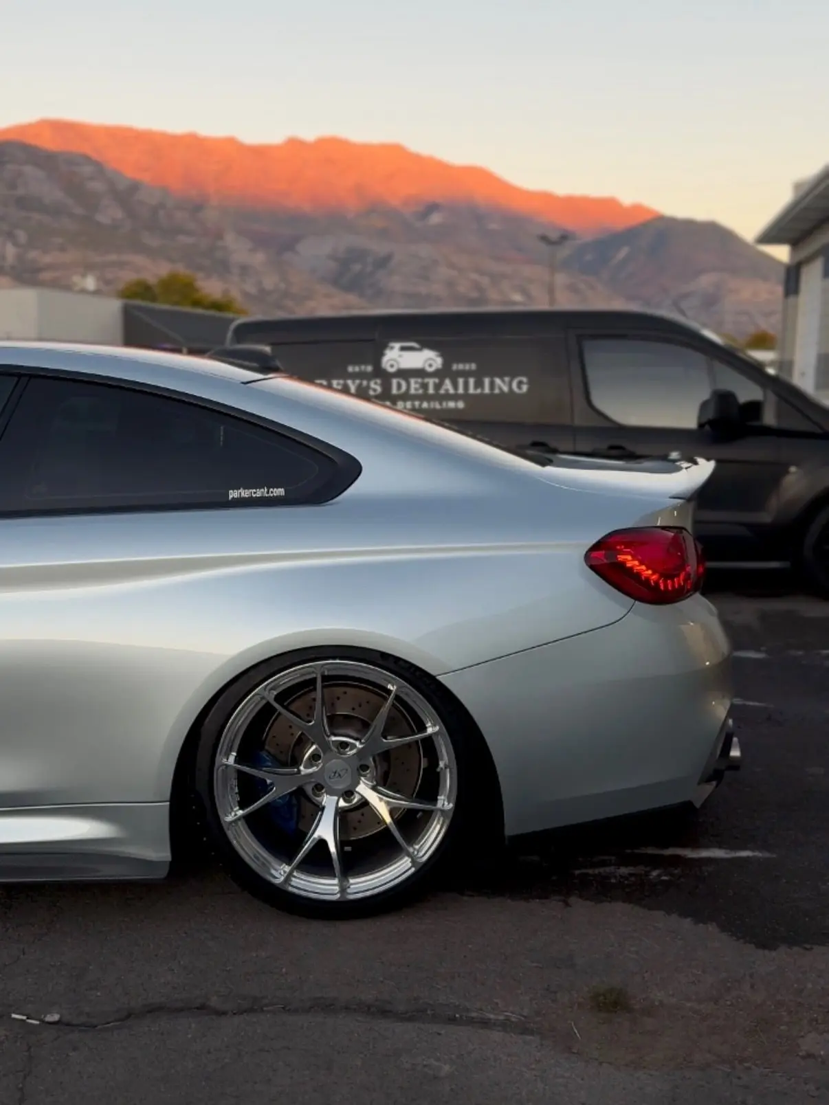 A silver BMW M4 outside the Bluffdale shop at sunrise