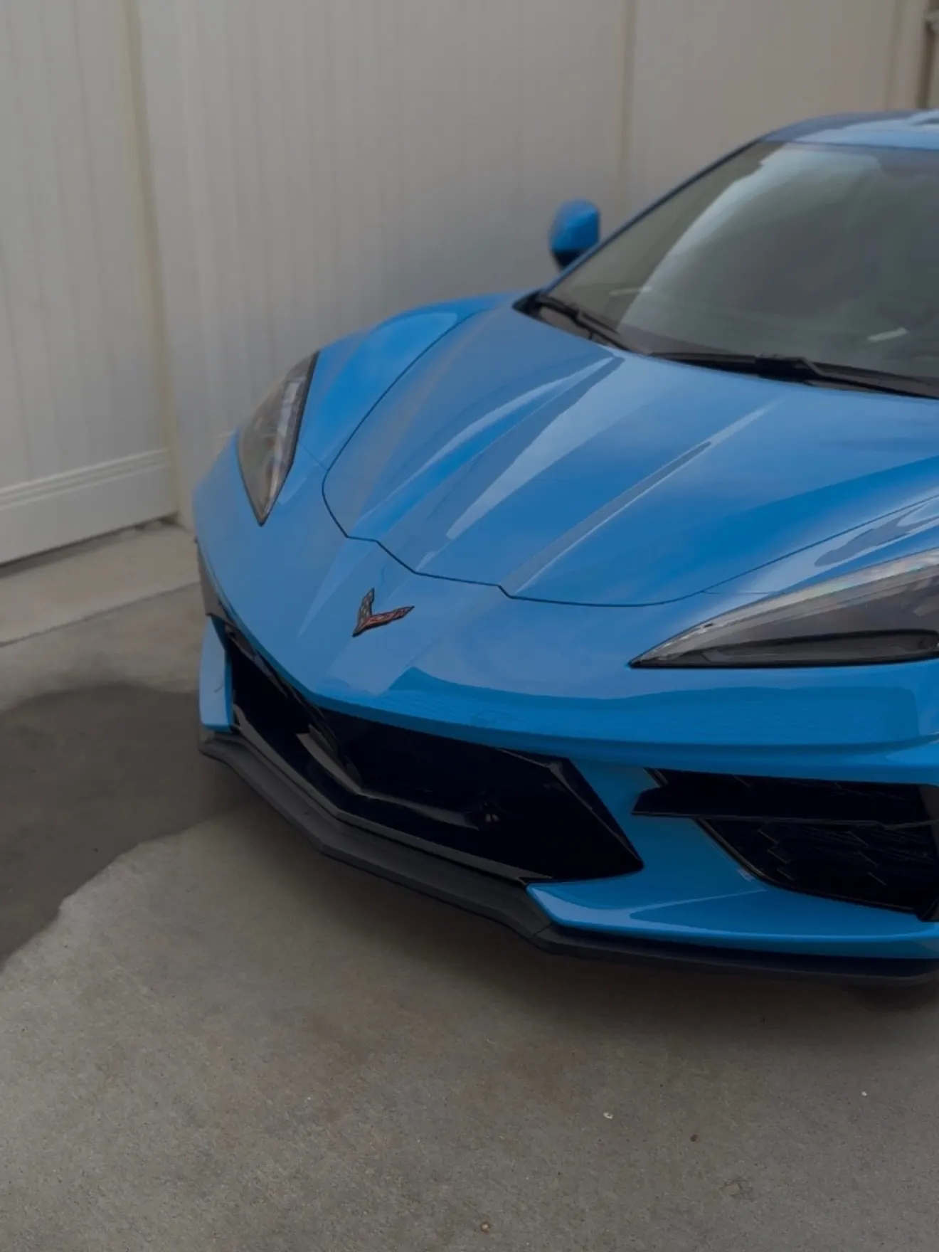 The coated nose of a Rapid Blue Corvette C8, deep and glossy