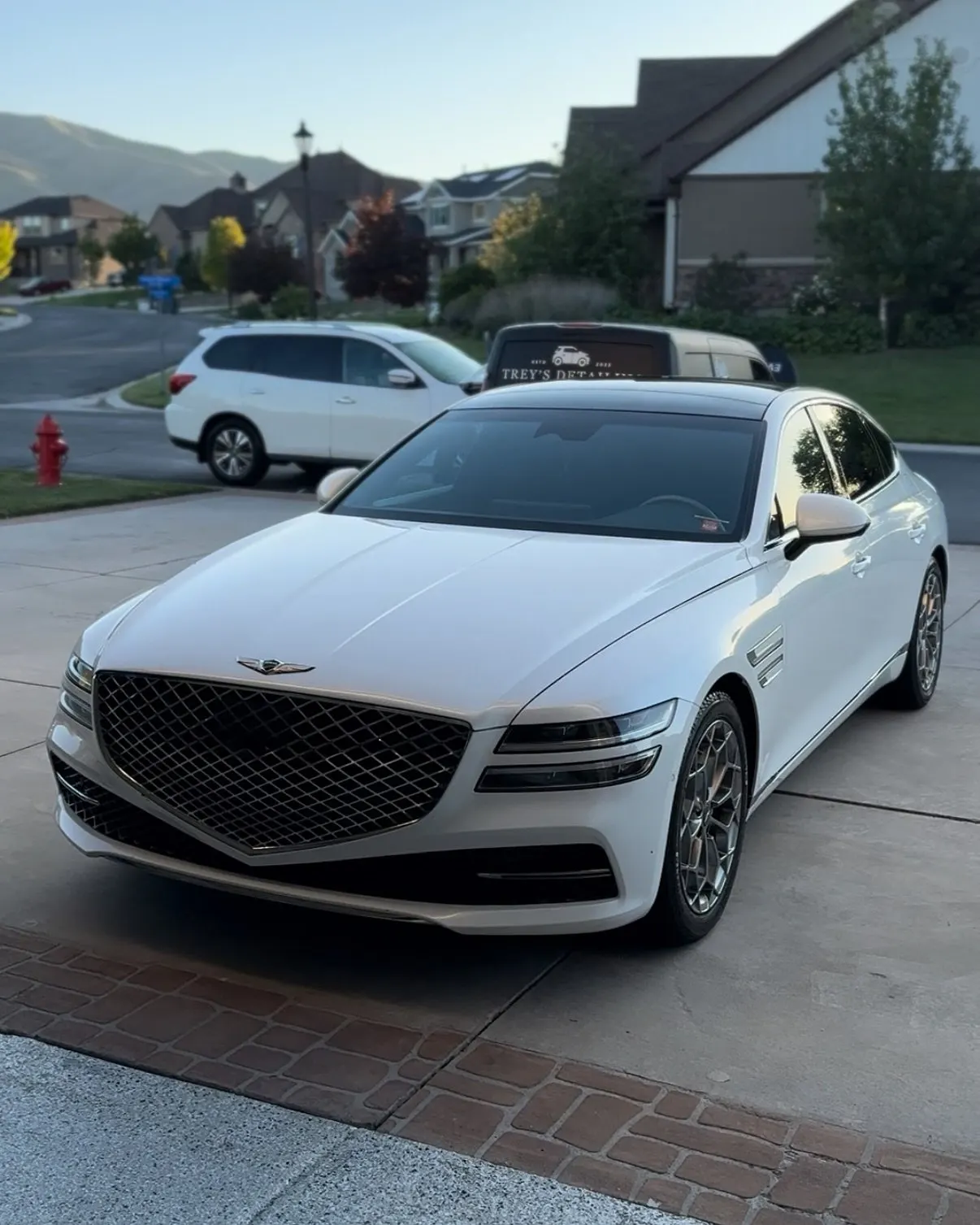 A white Genesis G80 from the front three-quarter