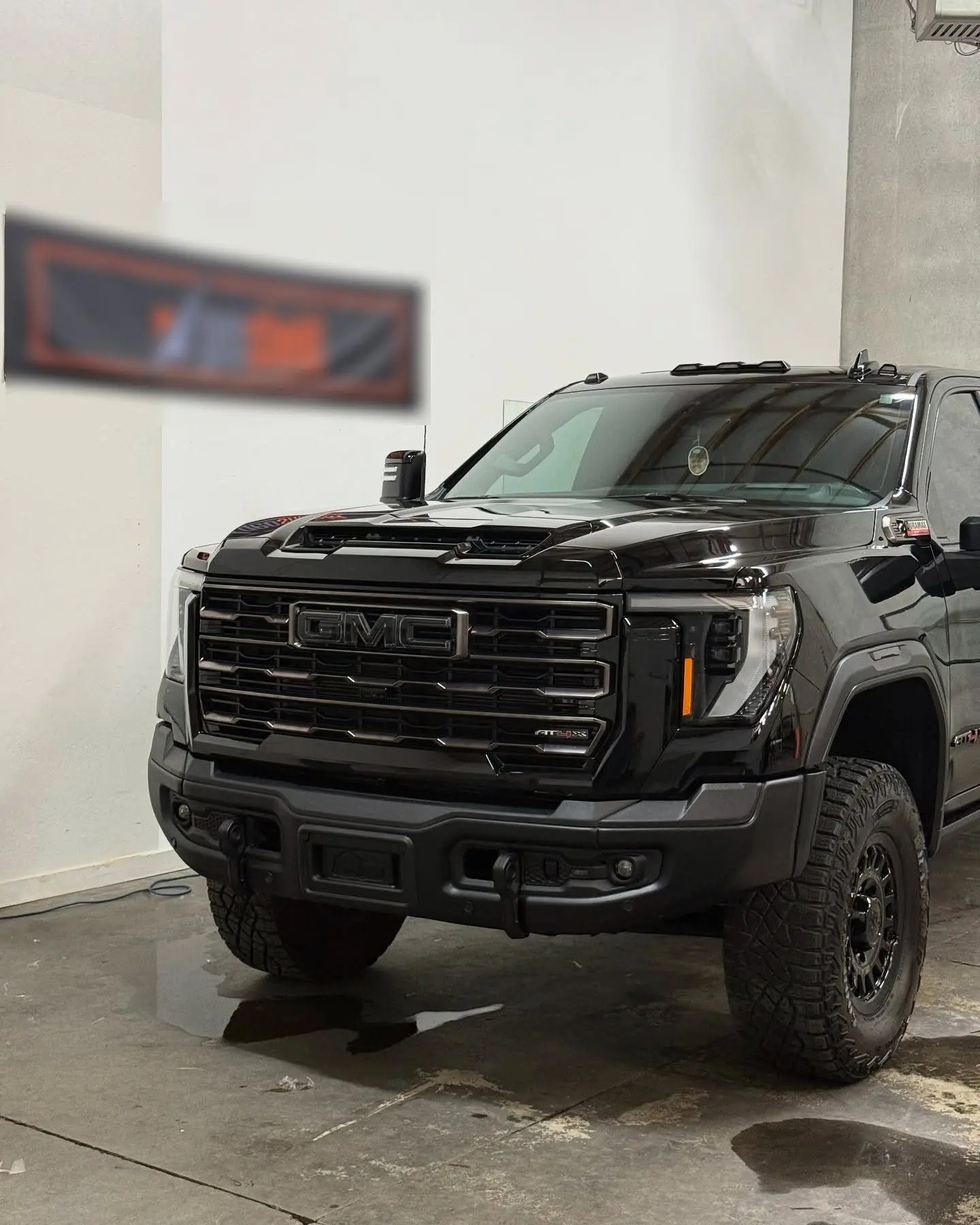 A black GMC 2500 AT4X in the wash bay, still wet