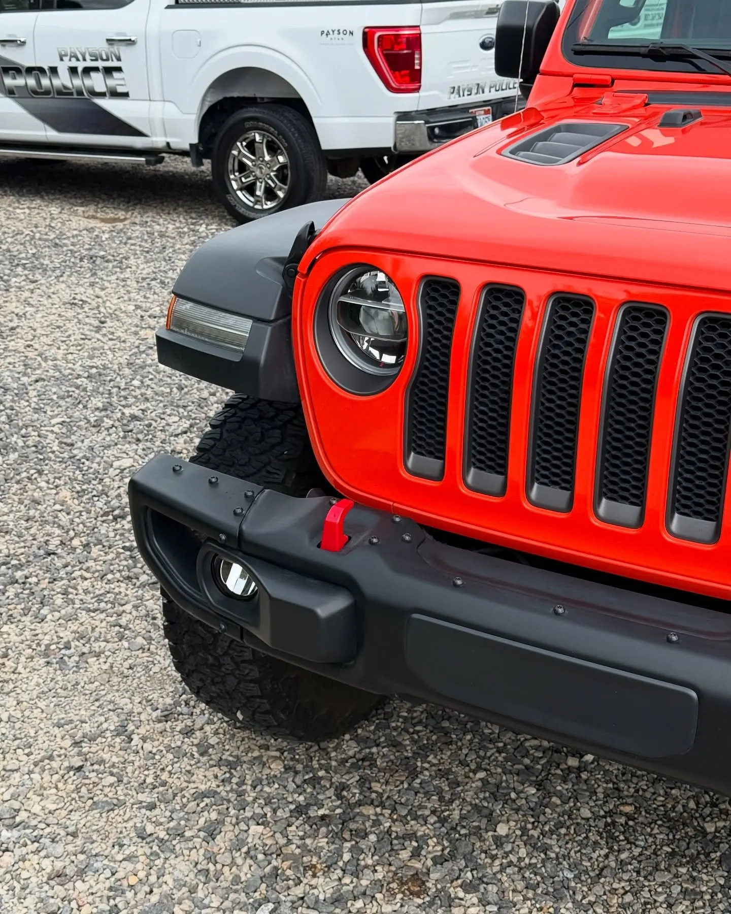 The grille of a red Jeep Wrangler Rubicon head-on, the first panels to catch stones