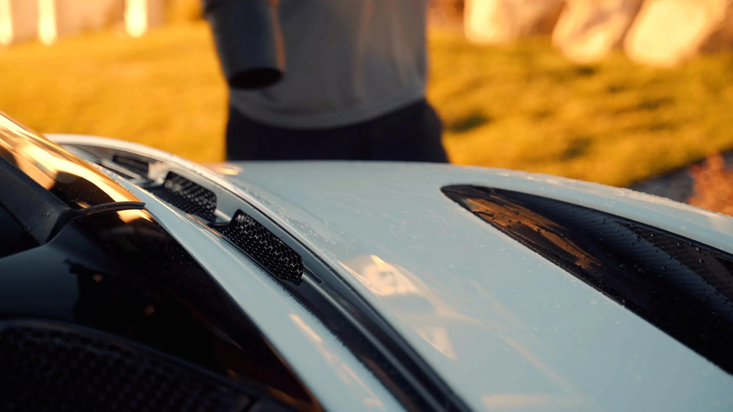 The wet, glossy rear deck of a white McLaren 720S mid-detail