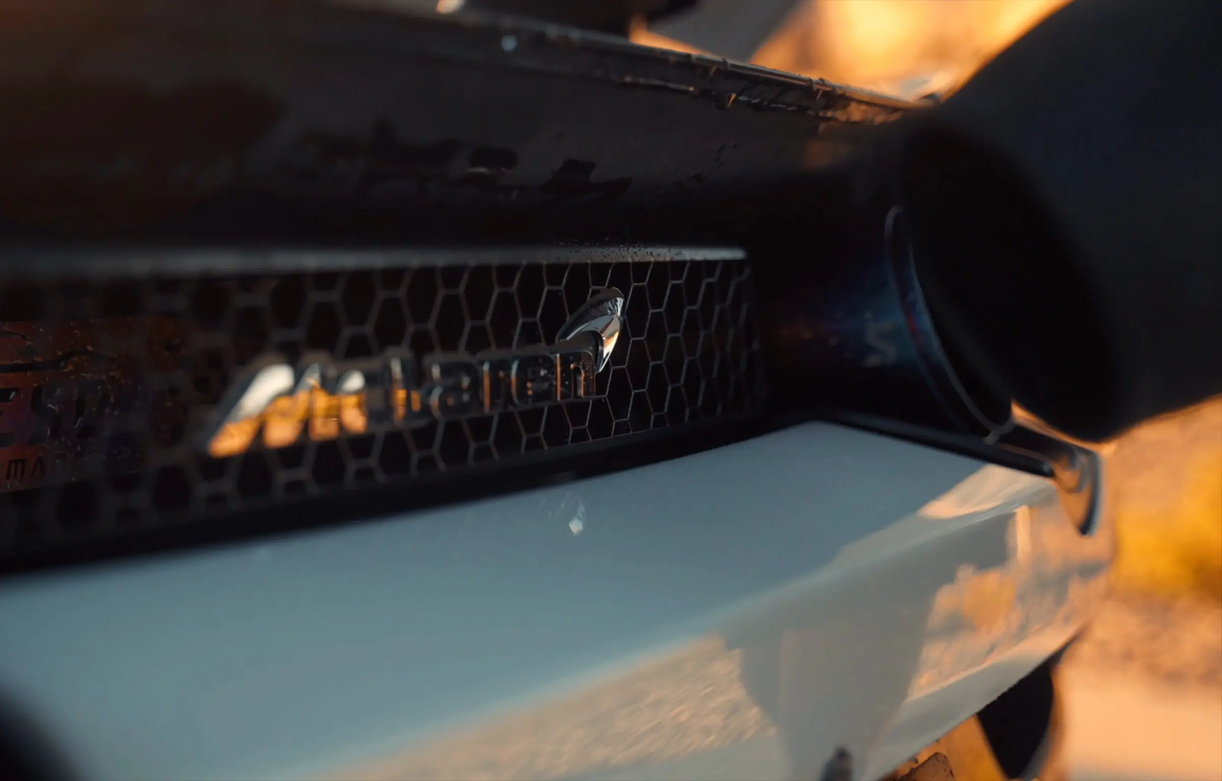 The mesh intake of a white McLaren 720S being blown dry