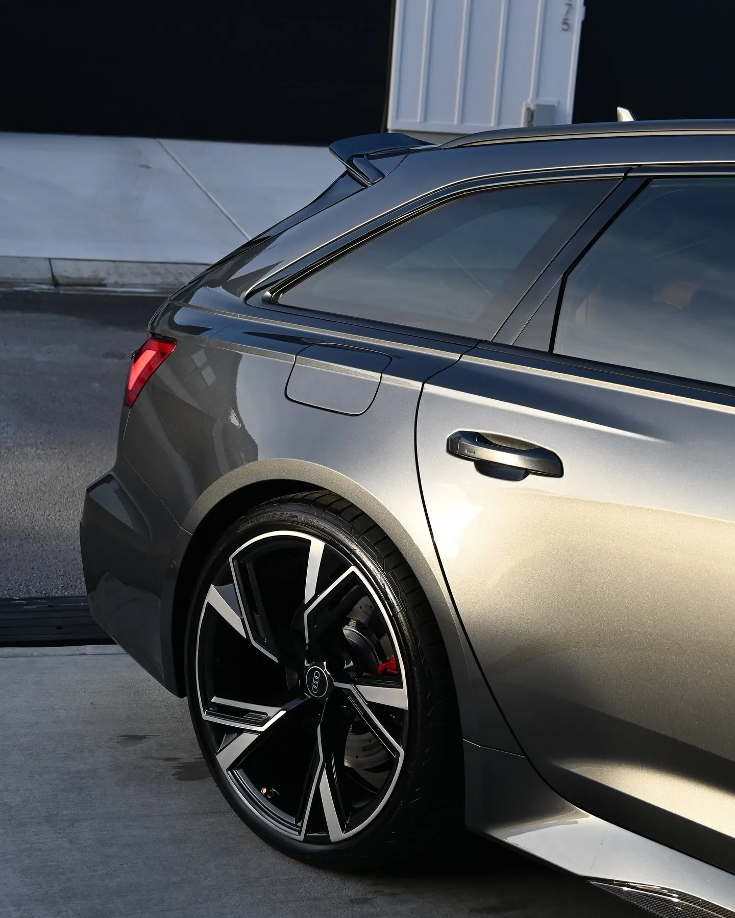 The rear three-quarter of a gray Audi RS6 in a satin finish
